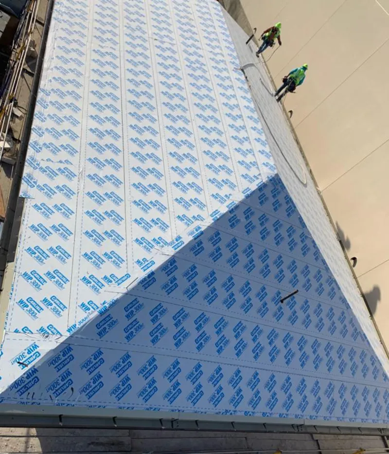 Professional roofers installing underlayment on a metal roof in Perkasie